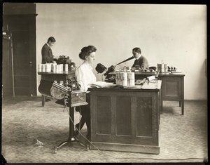 Vista interior de una mujer escribiendo a máquina desde una máquina de dictado y un hombre dictando en otra en la Edison Phonograph Co., West Orange, Nueva Jersey, 1903